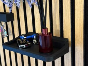 Matte black wall shelf on acoustic panel – modern minimalist interior decor