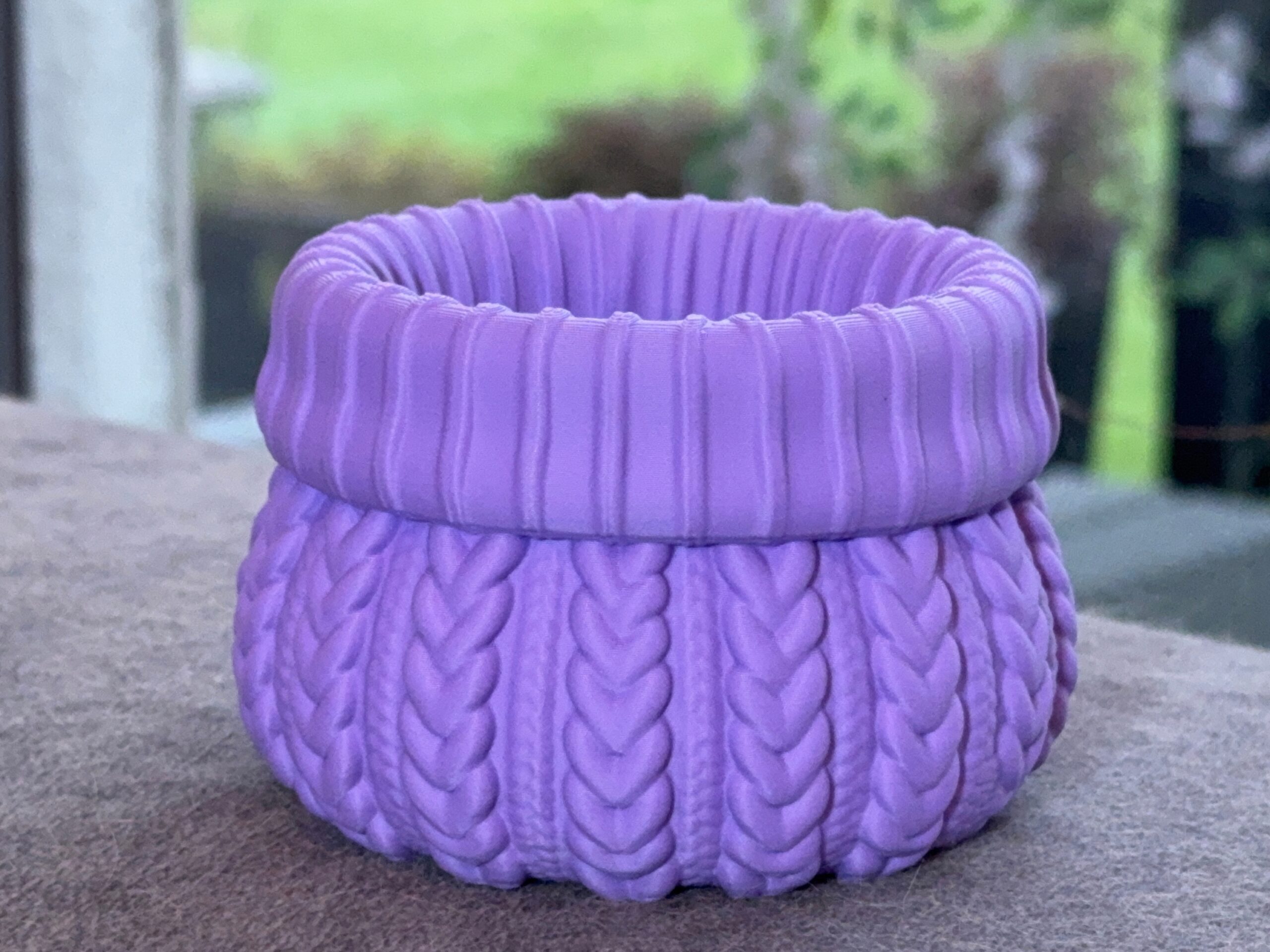 Empty purple sweater planter with the opening and raised knit pattern visible.