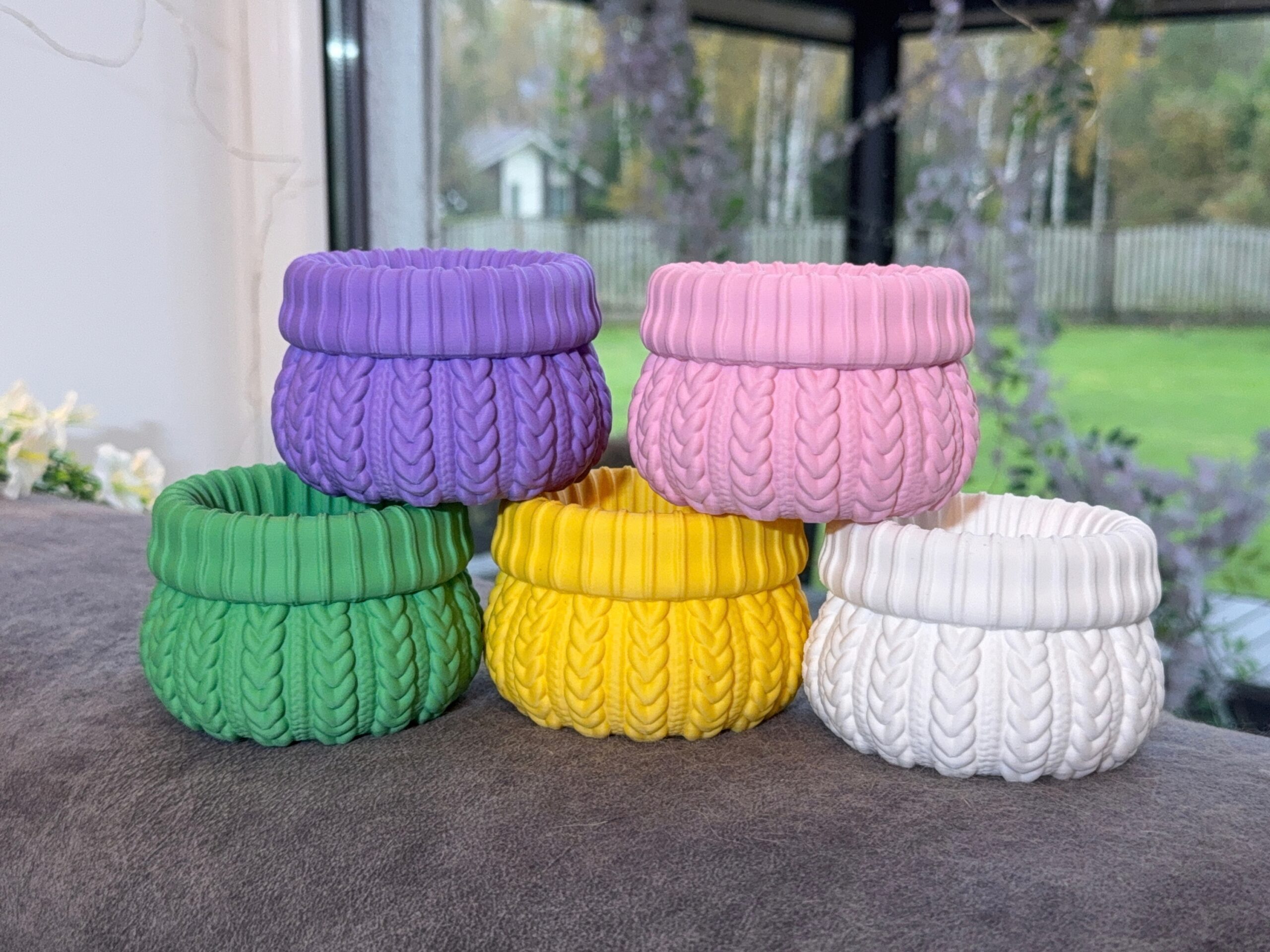 Five cable knit planters in purple, pink, green, yellow and white, showing the colour options.