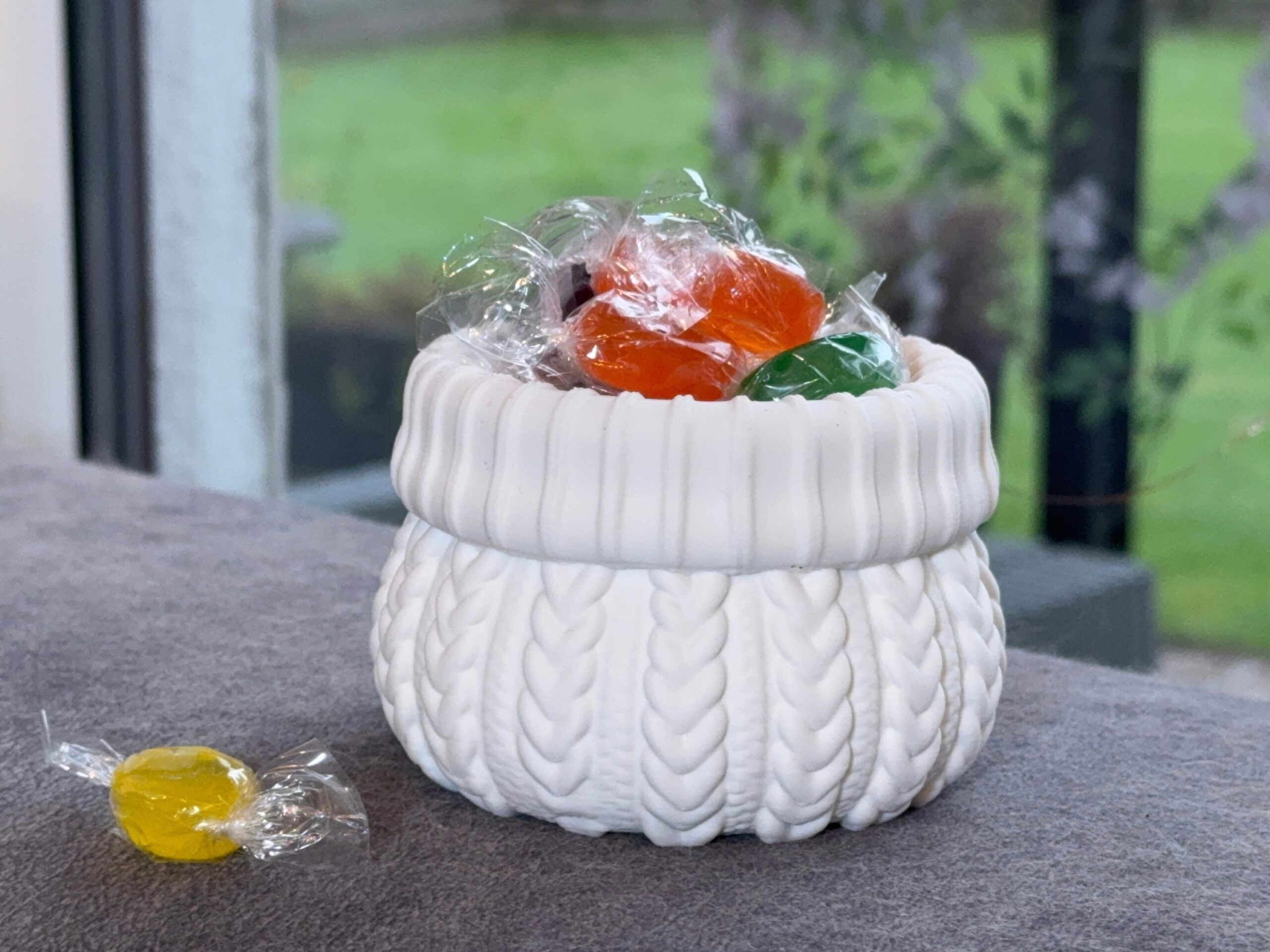White sweater-style pot filled with individually wrapped colourful sweets.